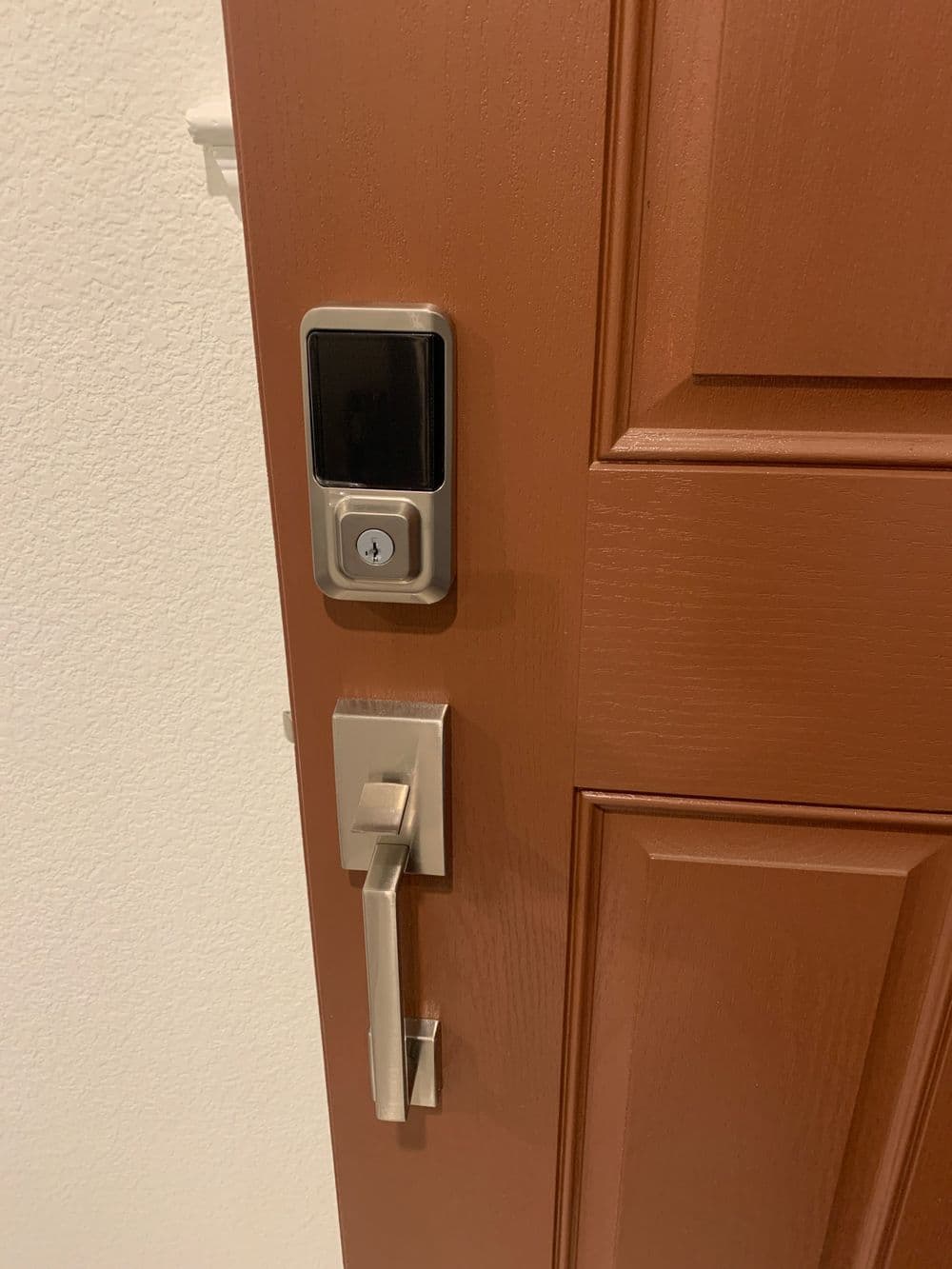 Smart lock and modern door handle on a wooden door. Ideal for home security solutions.