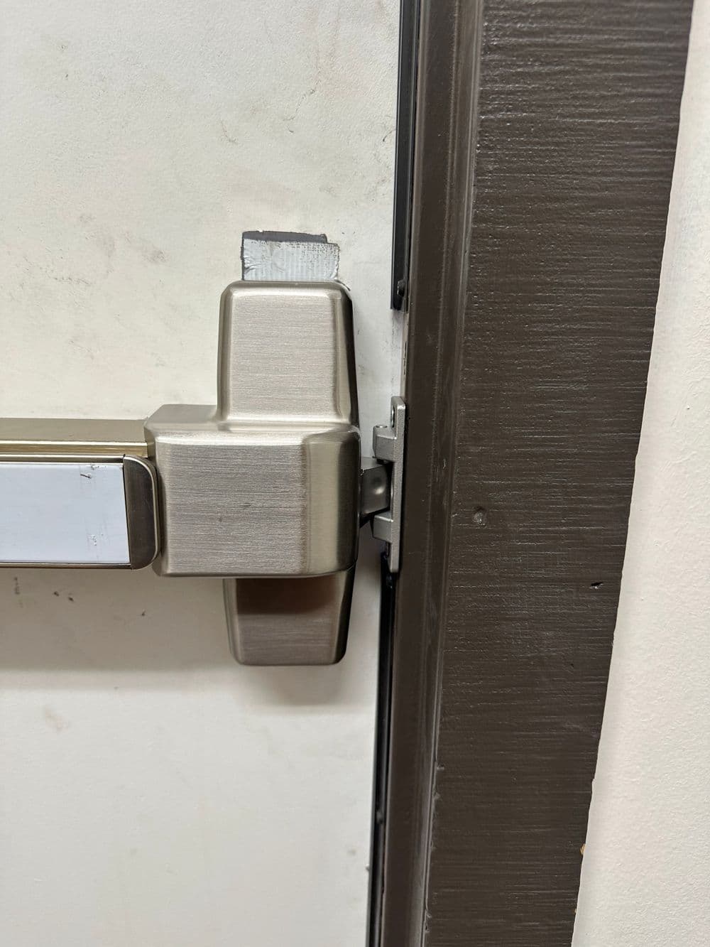 Close-up of a door handle and locking mechanism on a white door.