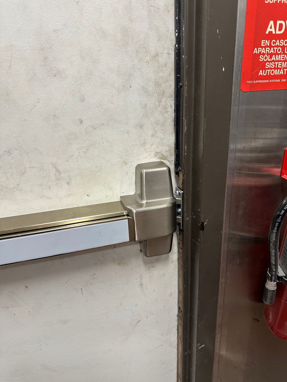 Elevator door detail showing metal handle and emergency equipment nearby.