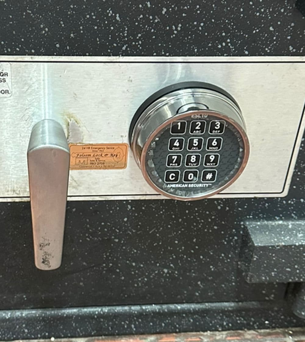 Close-up of a black safe's digital keypad and handle, showcasing security features.