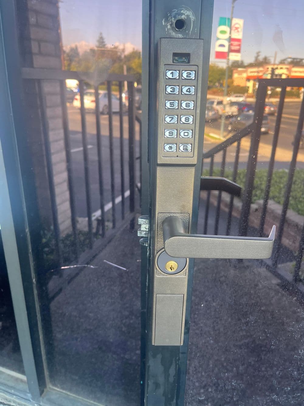 Keypad entry system on a door with a handle, showing numbers and keyhole for secure access.