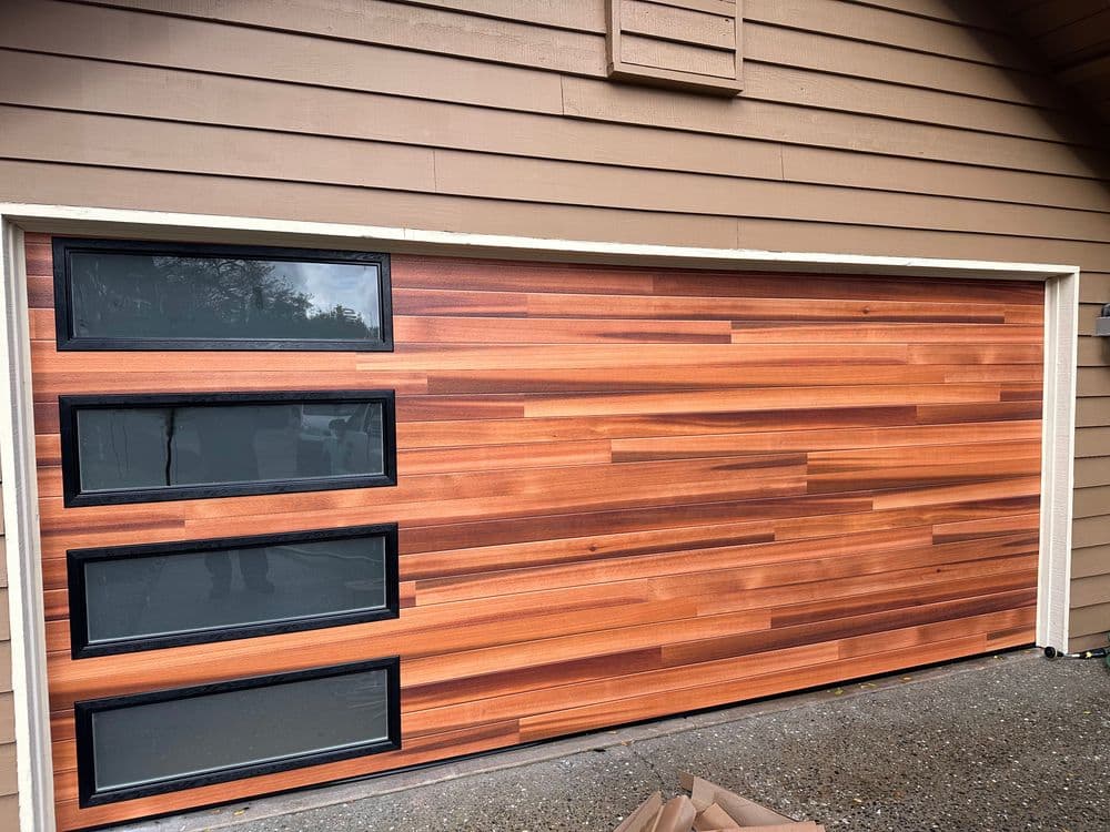 Modern wooden garage door with sleek vertical panels and large glass windows.
