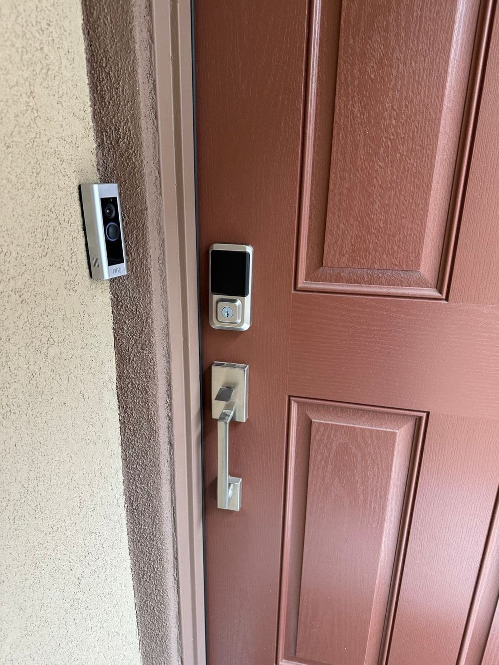 Modern door with digital smart lock and video doorbell, showcasing security features.