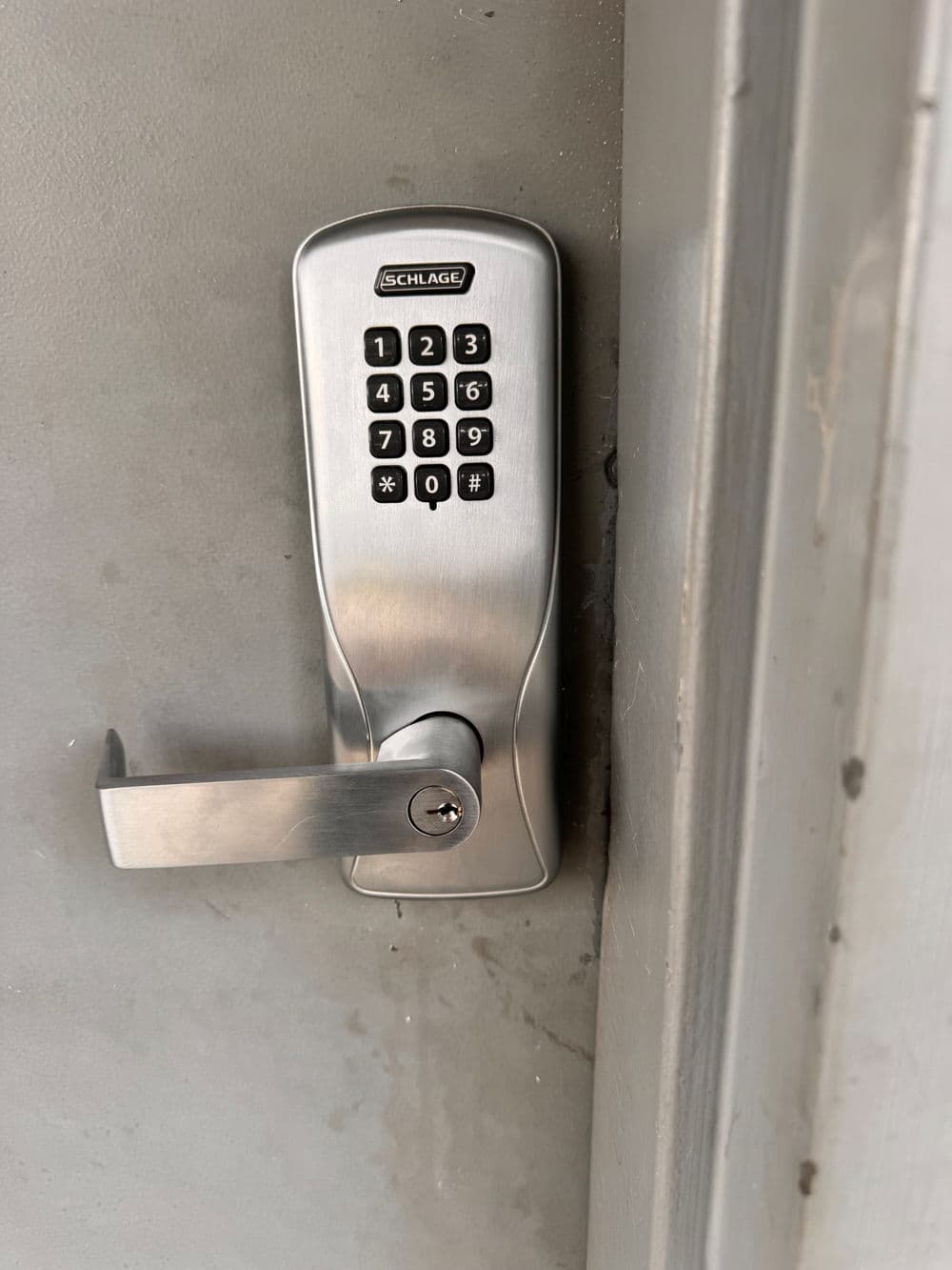 Schlage keyless entry lock with numeric keypad on a gray door.