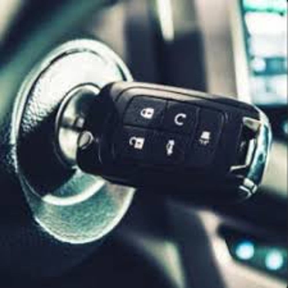 Car key fob inserted in the ignition of a vehicle, emphasizing modern automotive technology.